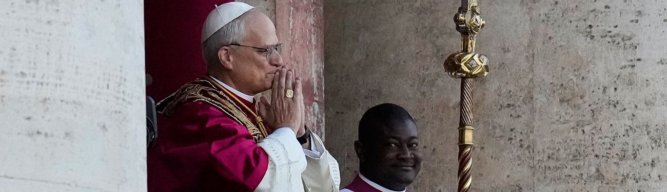 Pope in white and red robes praying beside a golden staff during a church ceremony