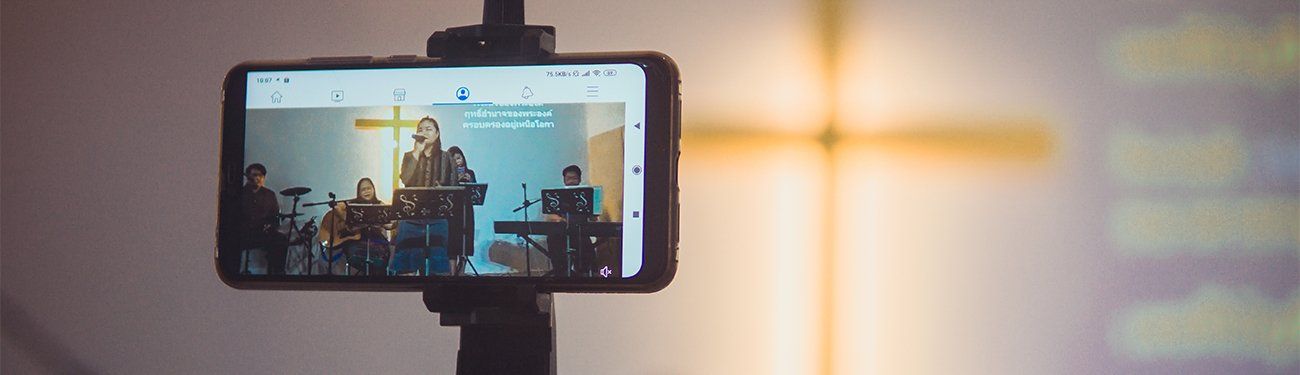 A cell phone is being used to record a church service.