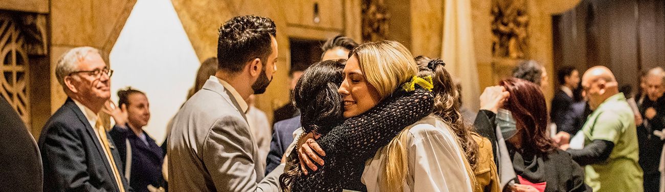 A group of people are hugging each other in a room.