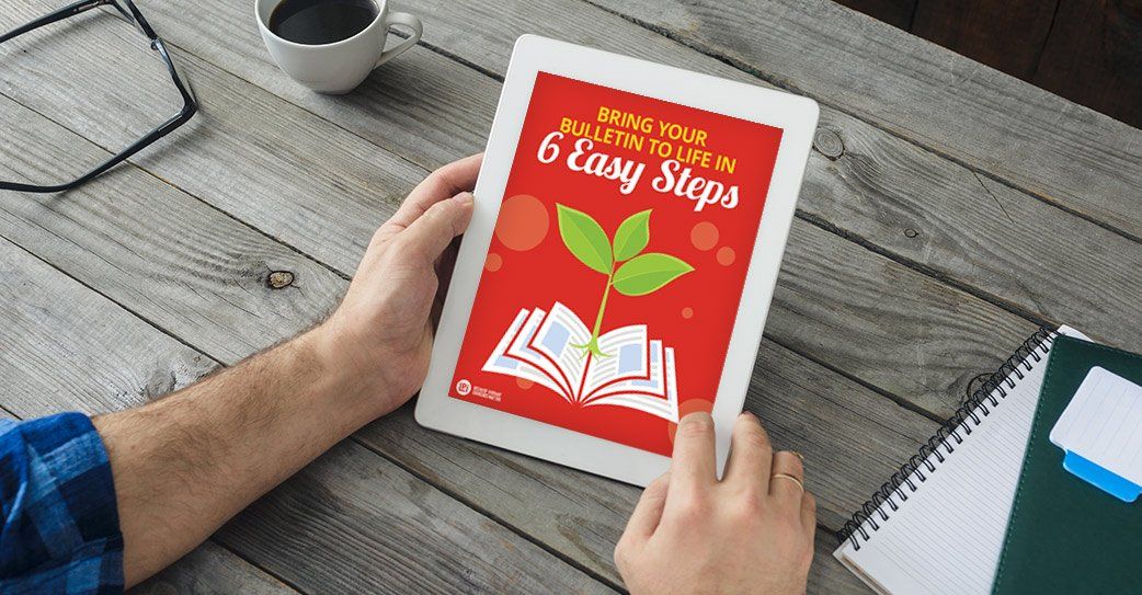 A person is holding a tablet with a book on it sprouting a leaf.