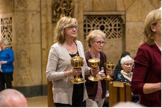 A group of women holding chalices in a church.