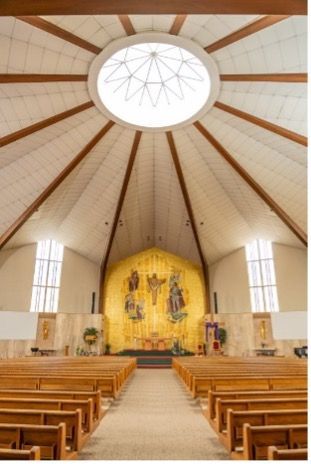 The inside of a church with rows of wooden benches.