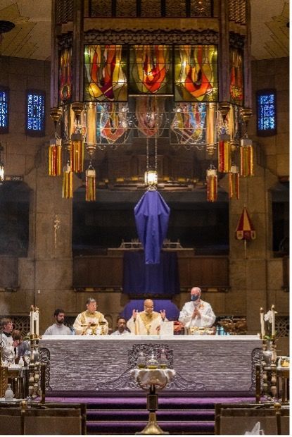 A group of people are sitting at an altar in a church.