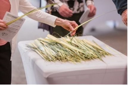 A woman is seting a palm leaf on a table.