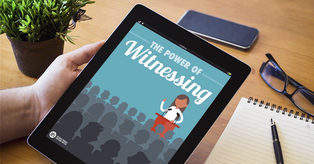 A person is holding a tablet with the power of witnessing on the screen.