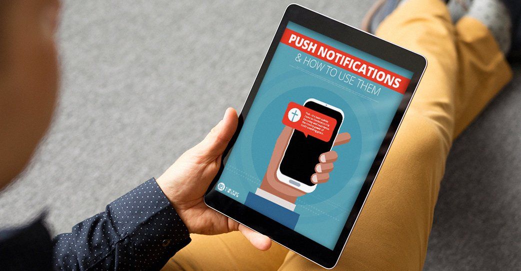 A person is holding a tablet that says push notifications on it.