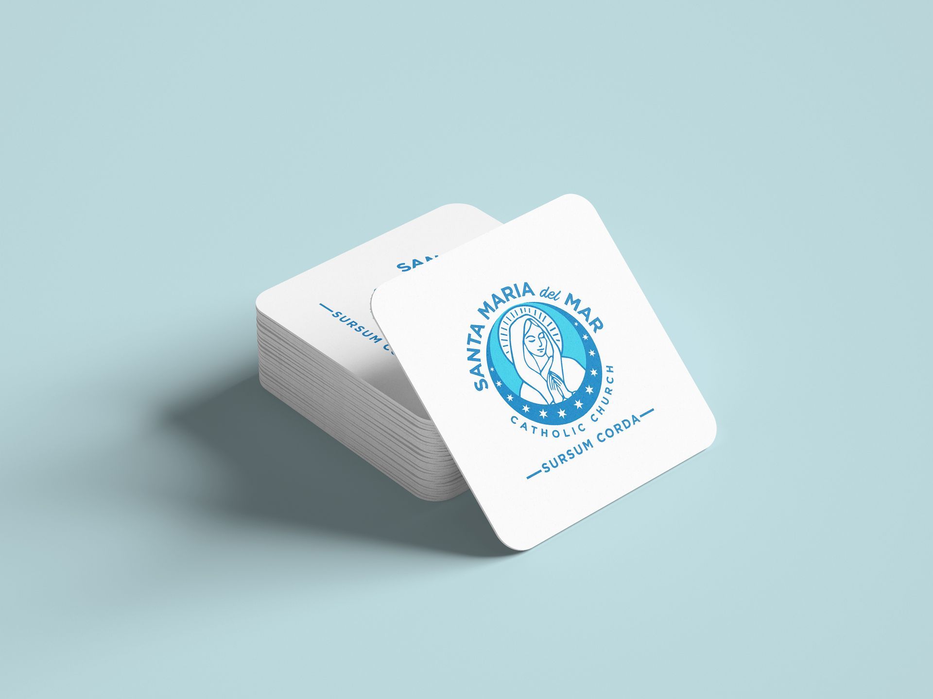 A stack of business cards with a logo on them on a blue surface.