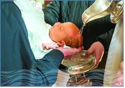 A baby is being baptized while being held.