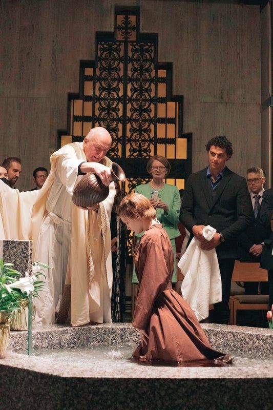 A man is baptizing a woman in a church