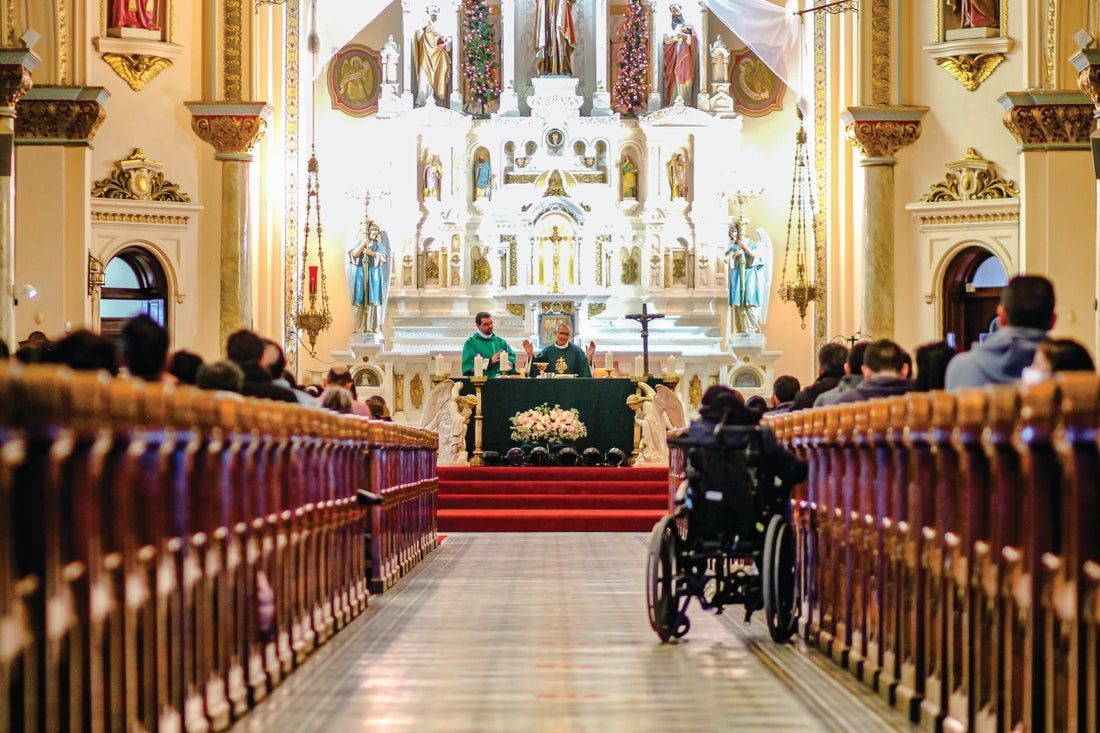A man in a wheelchair is sitting in a church.