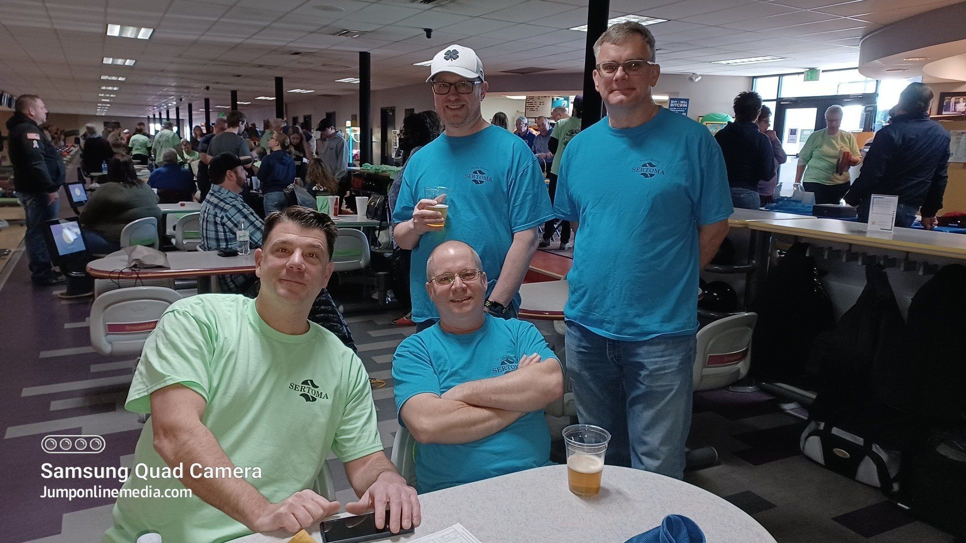 A group of men are posing for a picture in a bowling alley