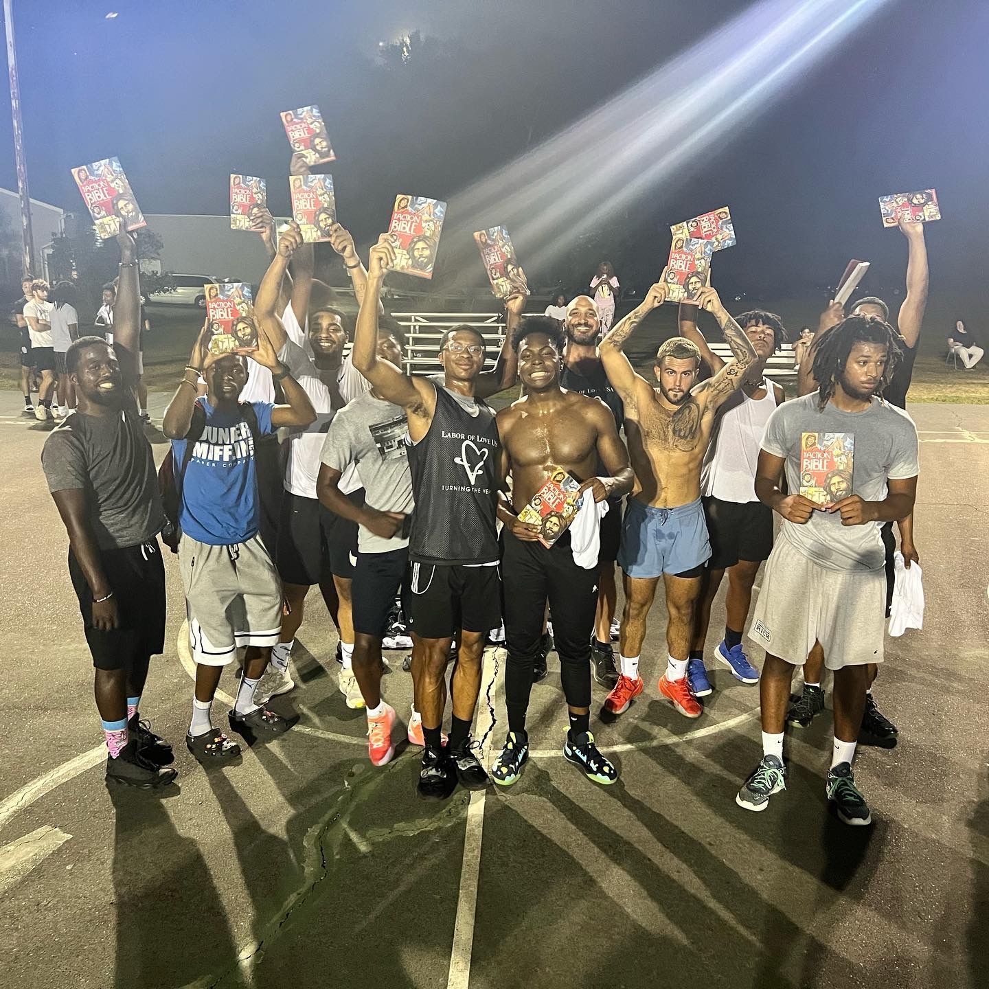 A group of young men are posing for a picture while holding up their arms in the air.