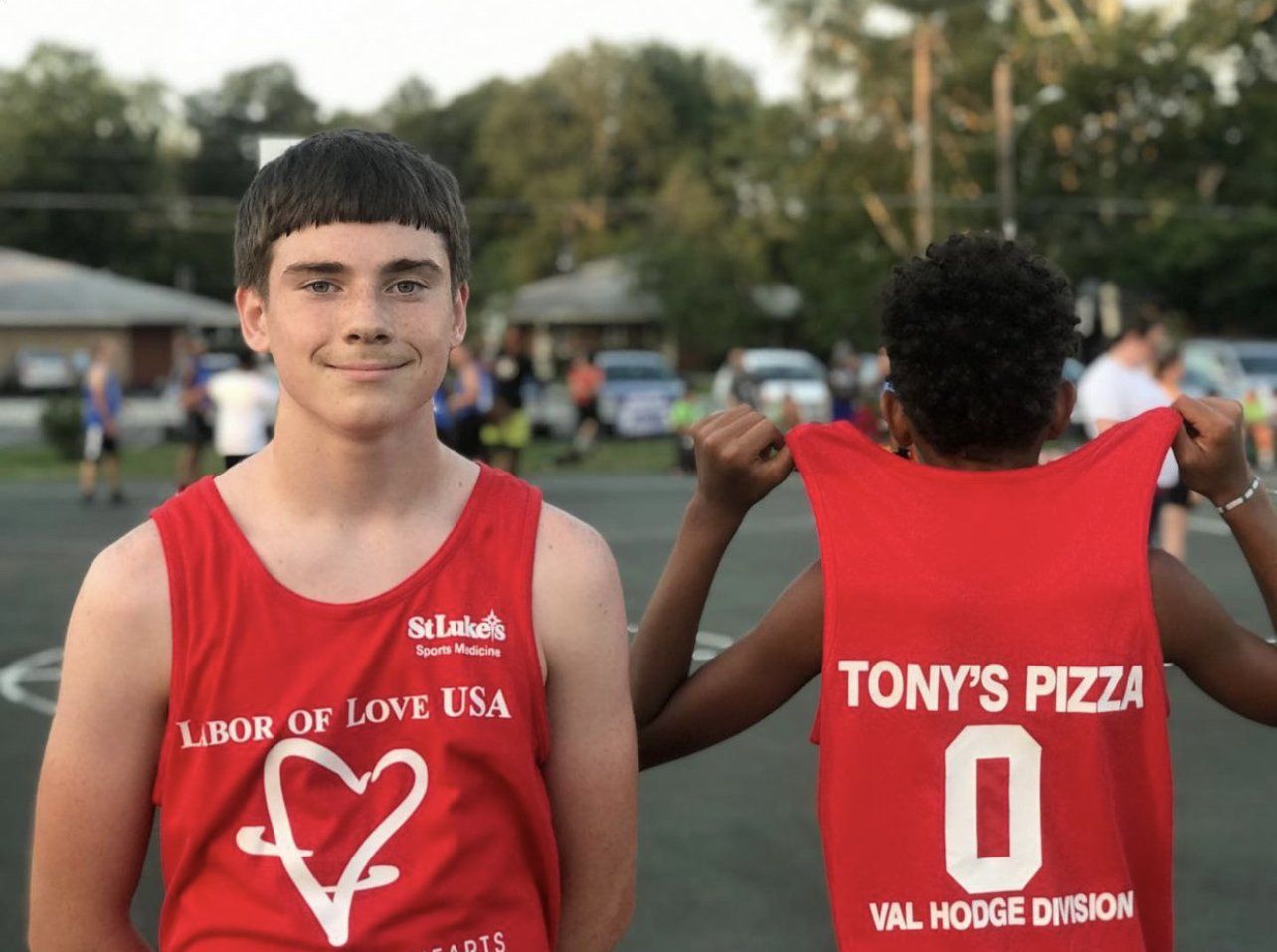A boy wearing a red tank top that says labor of love usa
