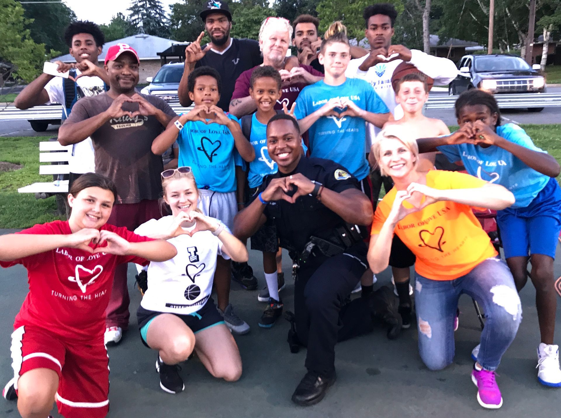 A group of people are making a heart shape with their hands