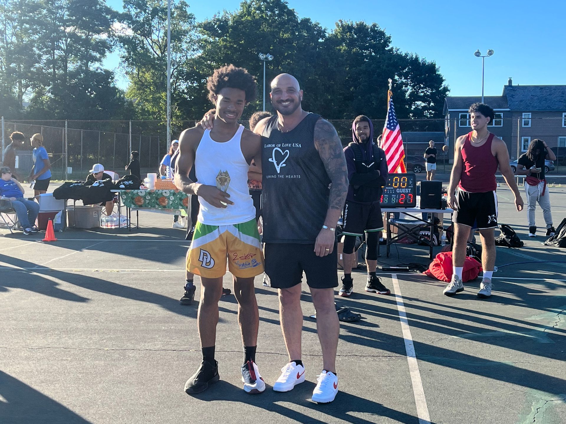 Two men are standing next to each other on a basketball court.