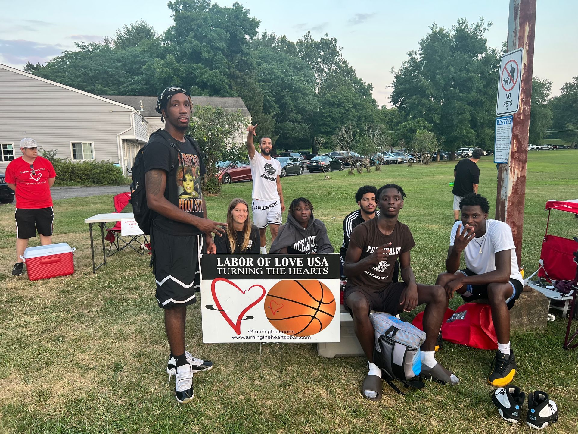 A group of people are sitting in a park with a sign that says `` league love usa ''.