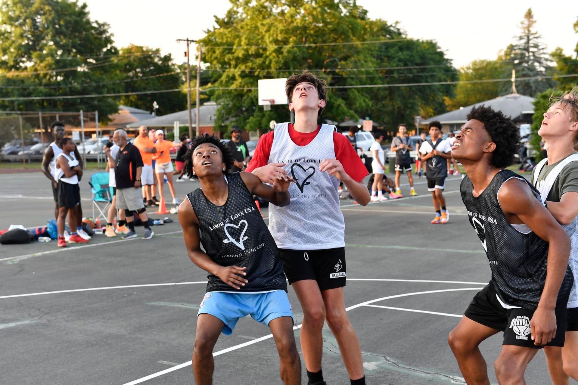 A group of young men are playing basketball on a court.