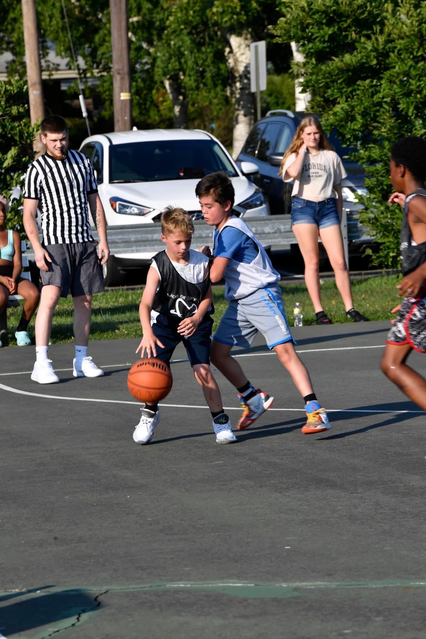 A group of young boys are playing basketball on a court.