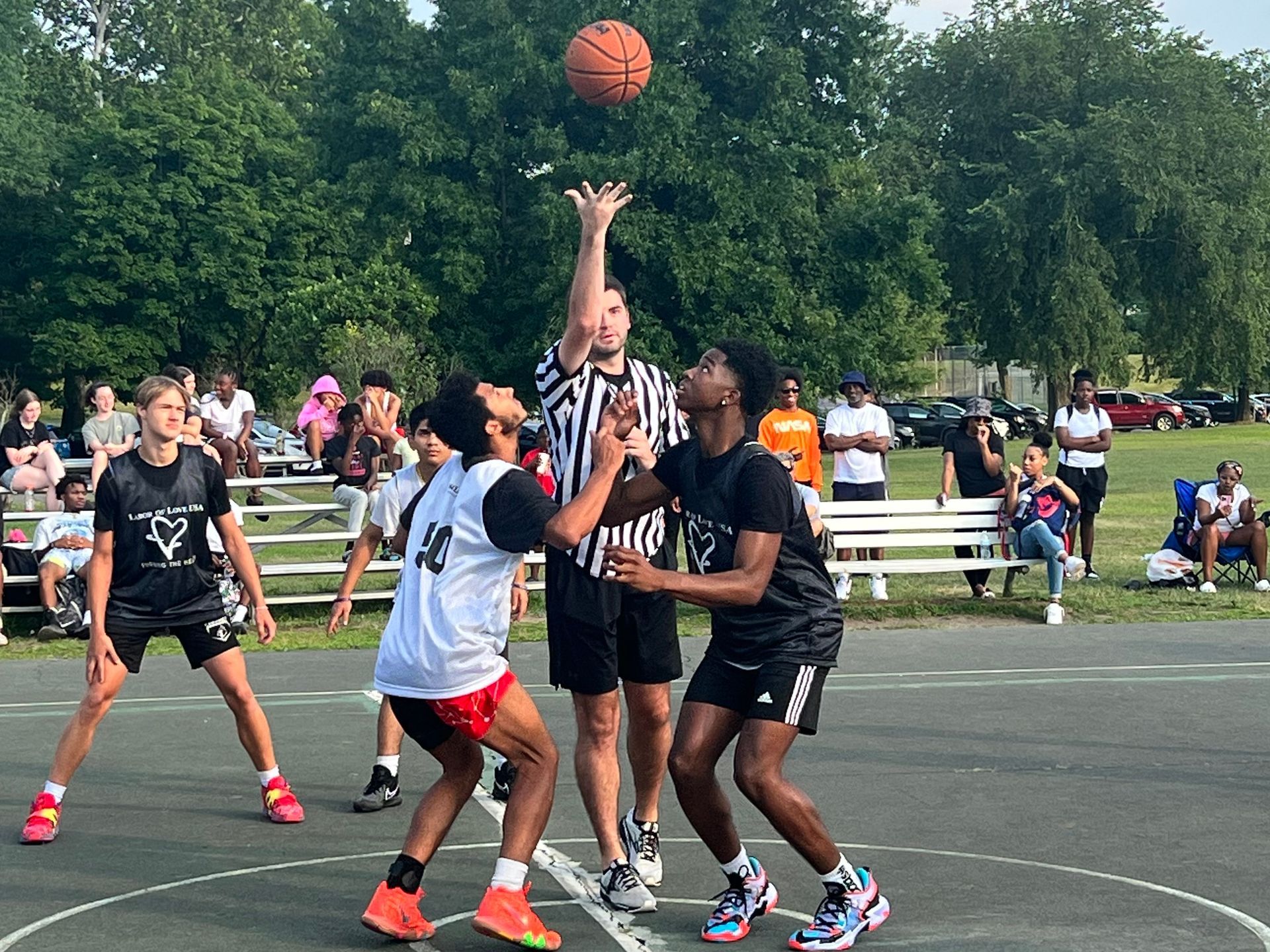A group of young men are playing basketball on a court.