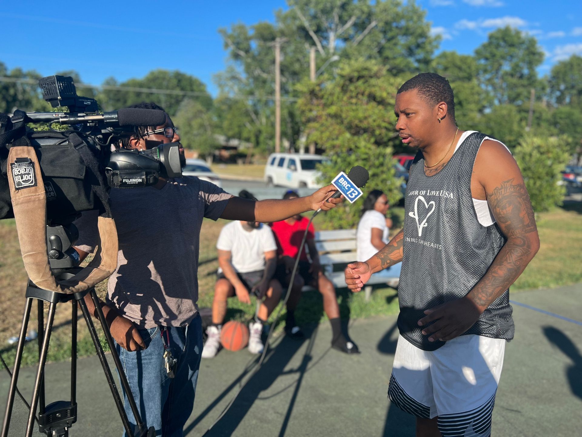 A man is being interviewed by a cameraman with a microphone.