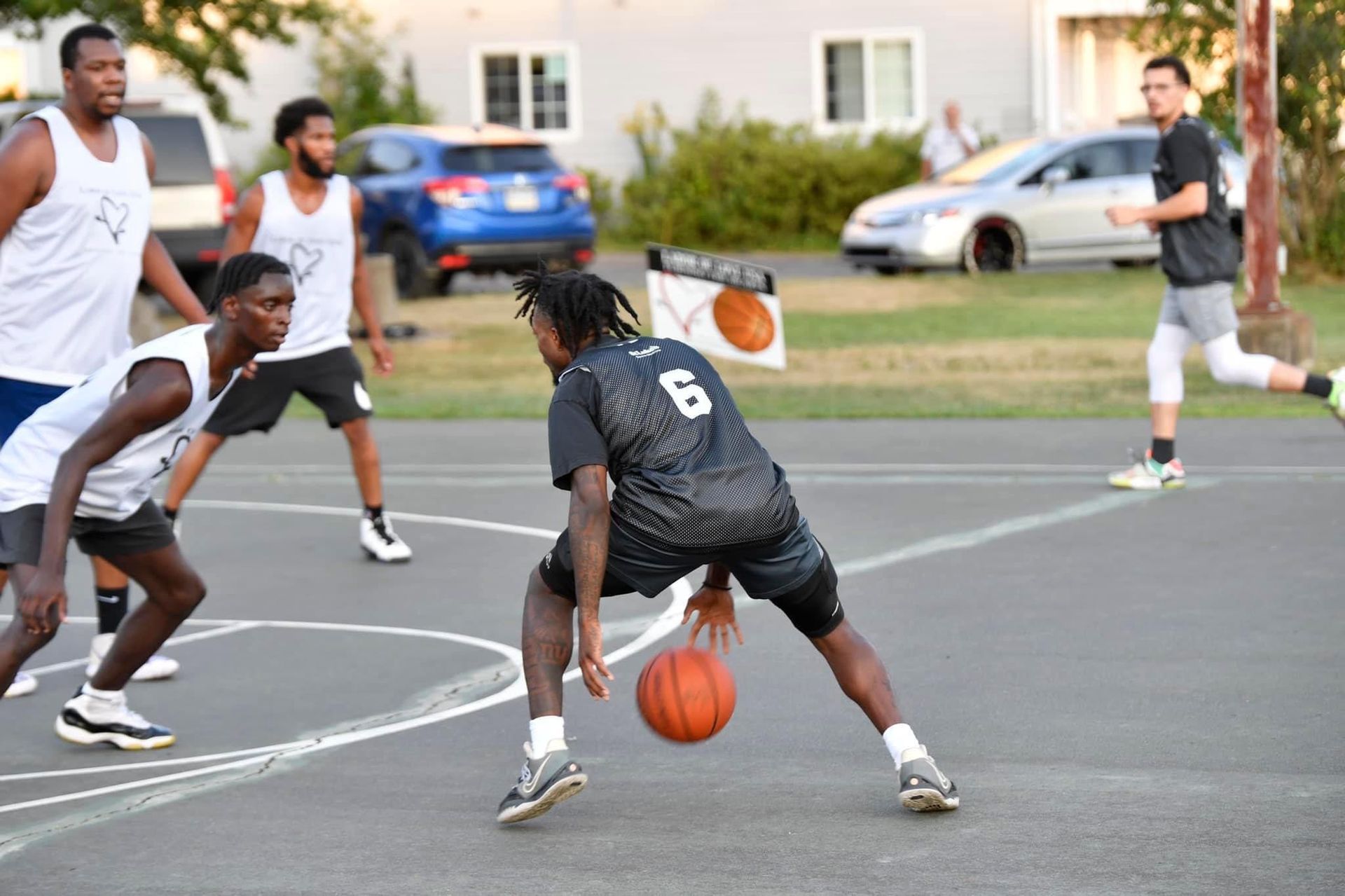 A group of young men are playing basketball on a court.