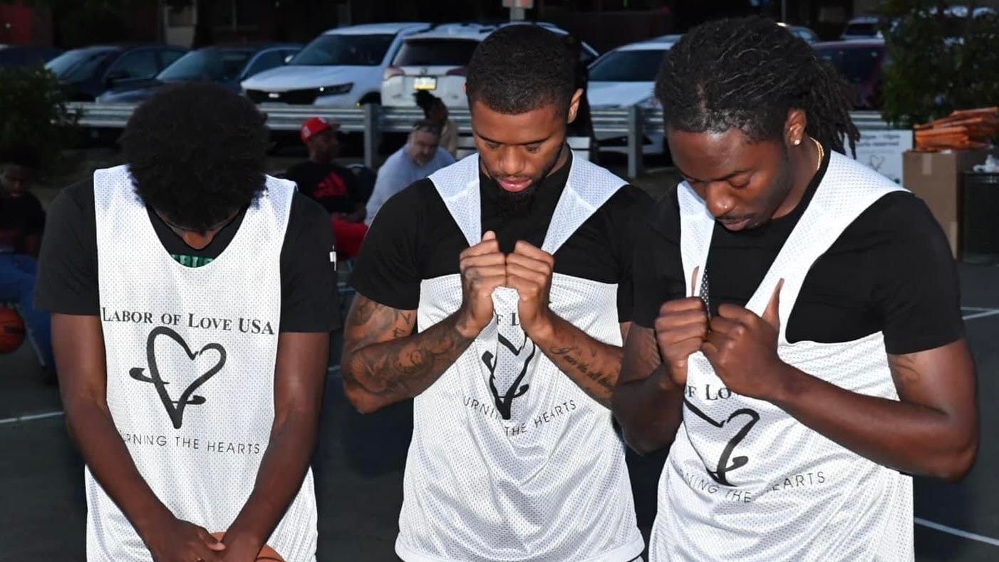 Three men are praying with their hands folded in front of them