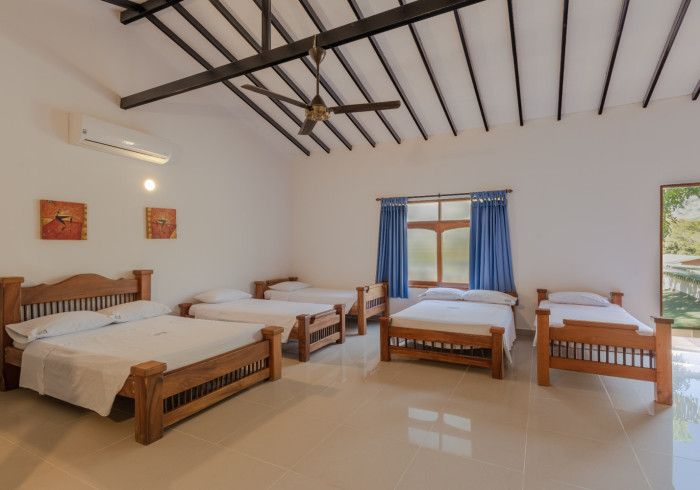 Una habitación grande con muchas camas y un ventilador de techo.