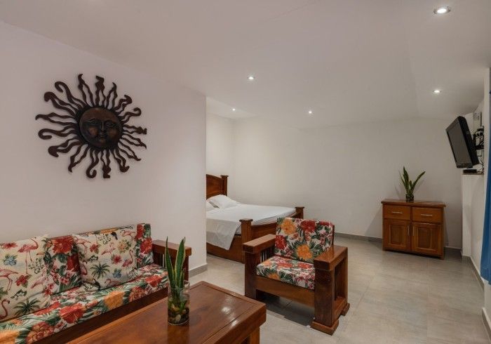 Una sala de estar con un sofá, una silla, una mesa y una cama.