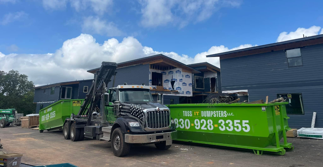 Dumpster rental getting dropped off at a construction site