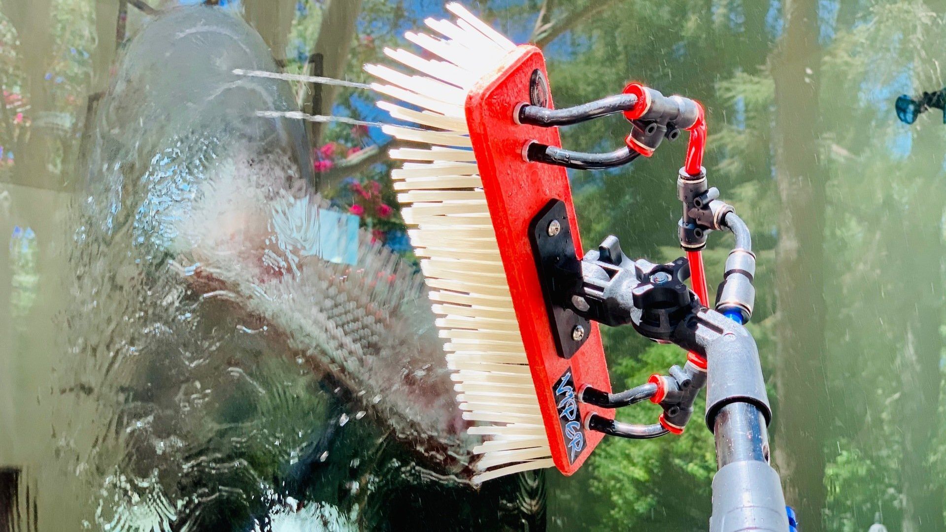 A brush is being used to clean a window.