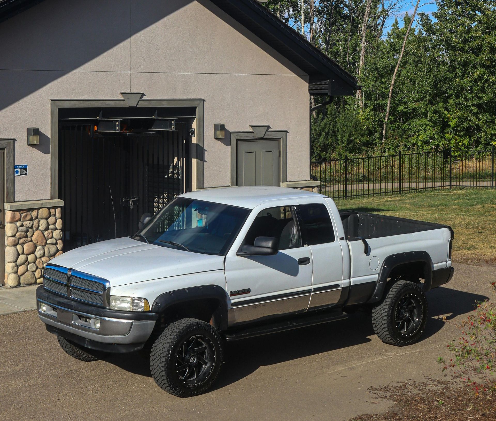 A white truck is parked in front of a garage