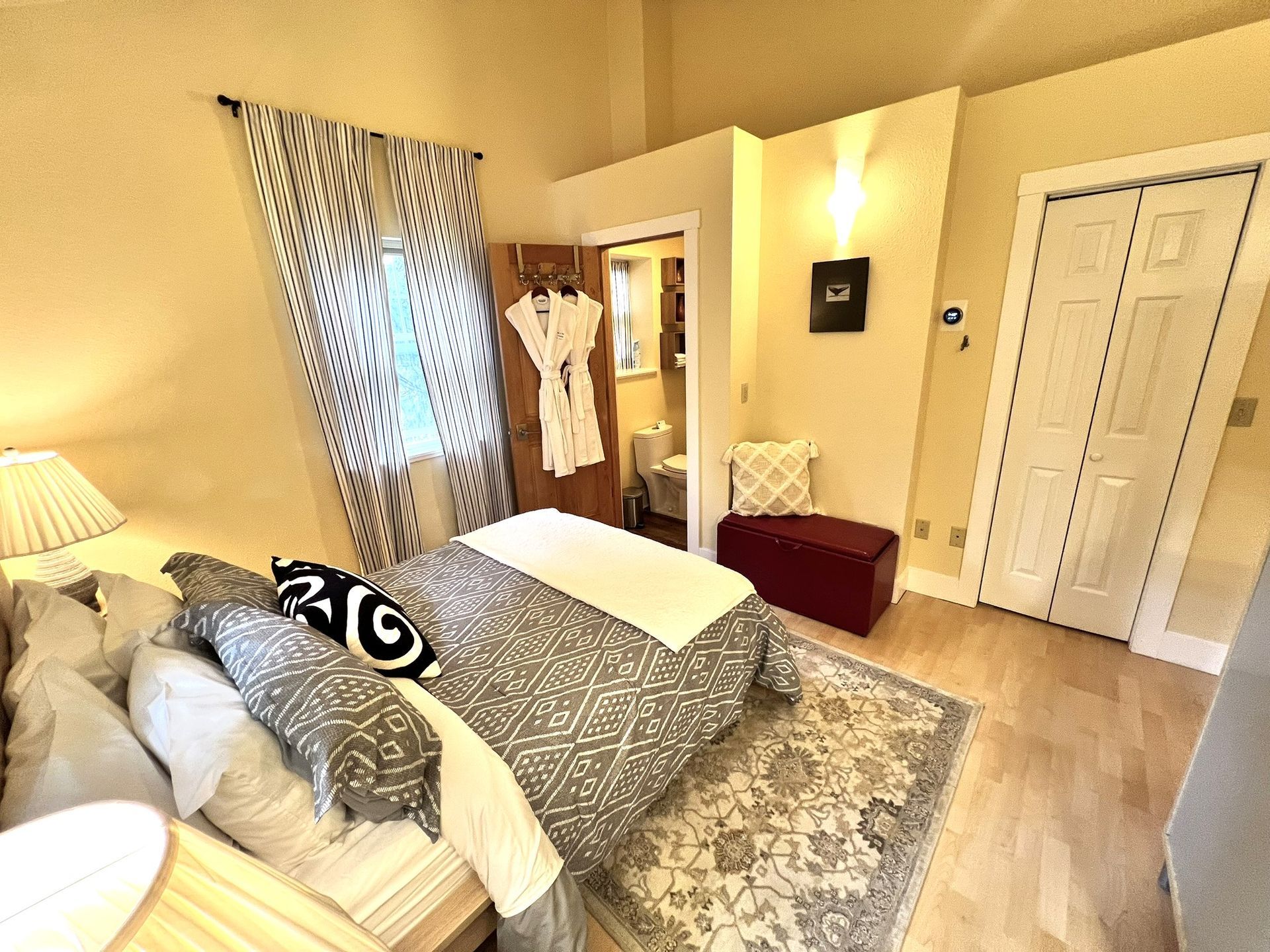 A bedroom with a large bed and a rug