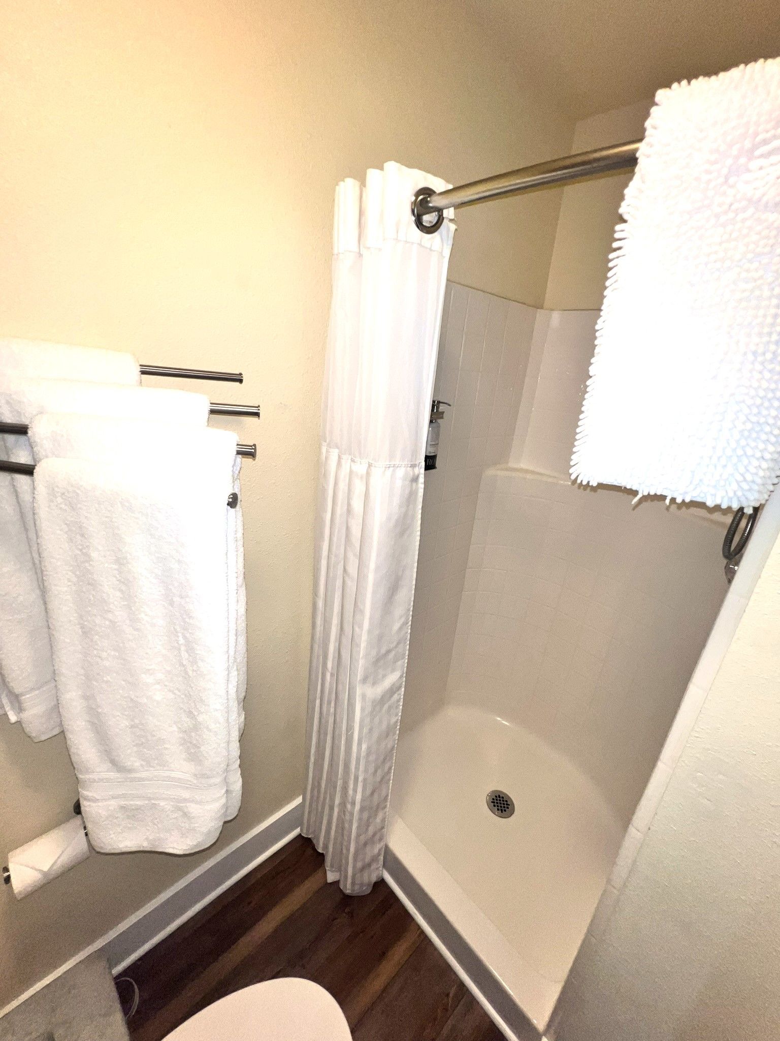 A bathroom with a toilet and a shower stall