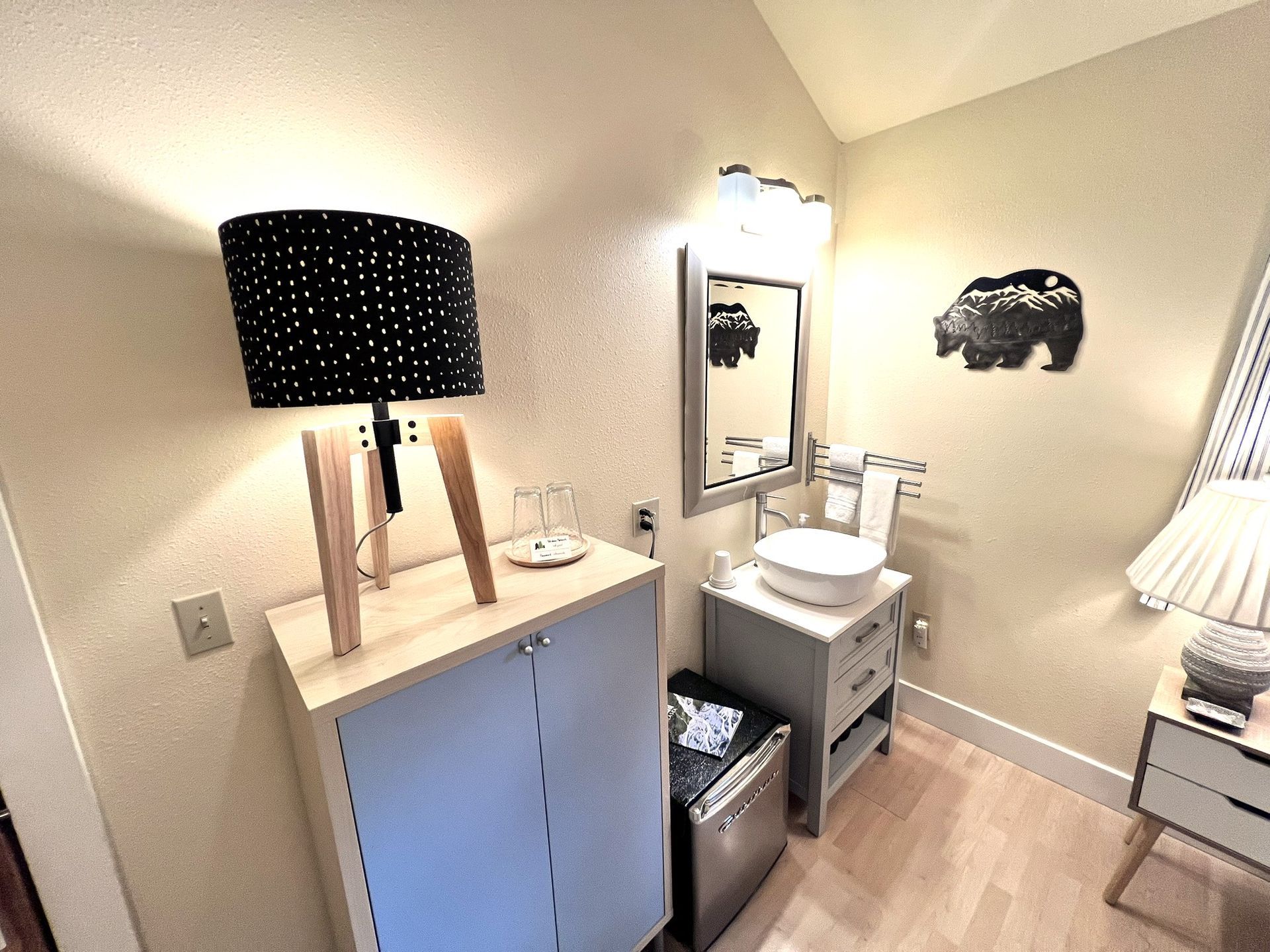 A bathroom with a sink , mirror and lamp