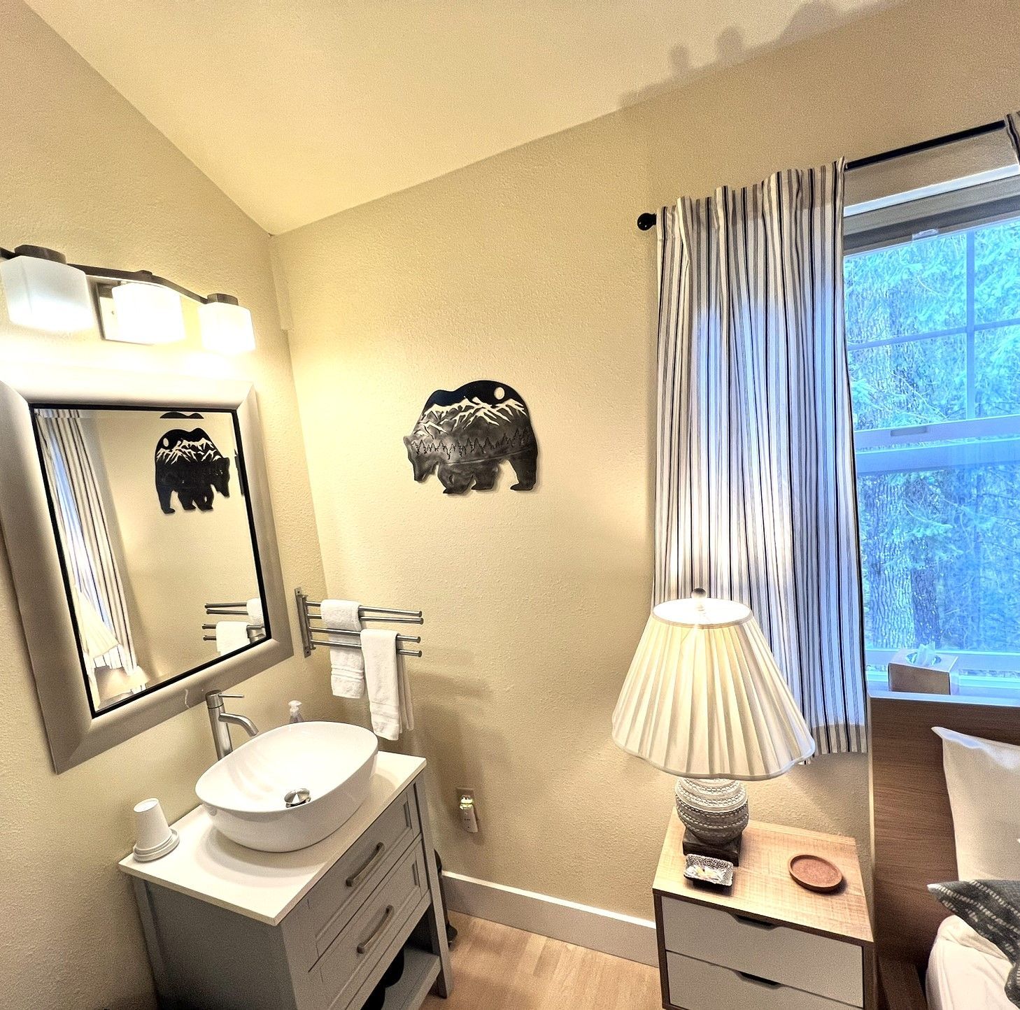 A bathroom with a sink a mirror and a lamp