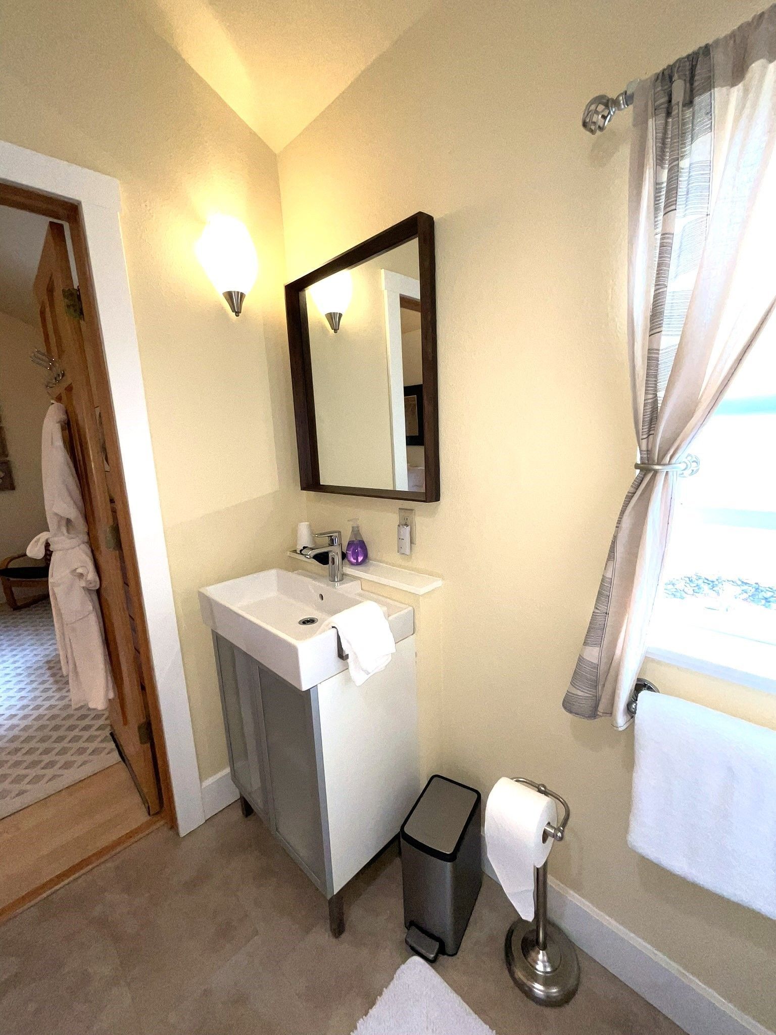 A bathroom with a sink a mirror and a window