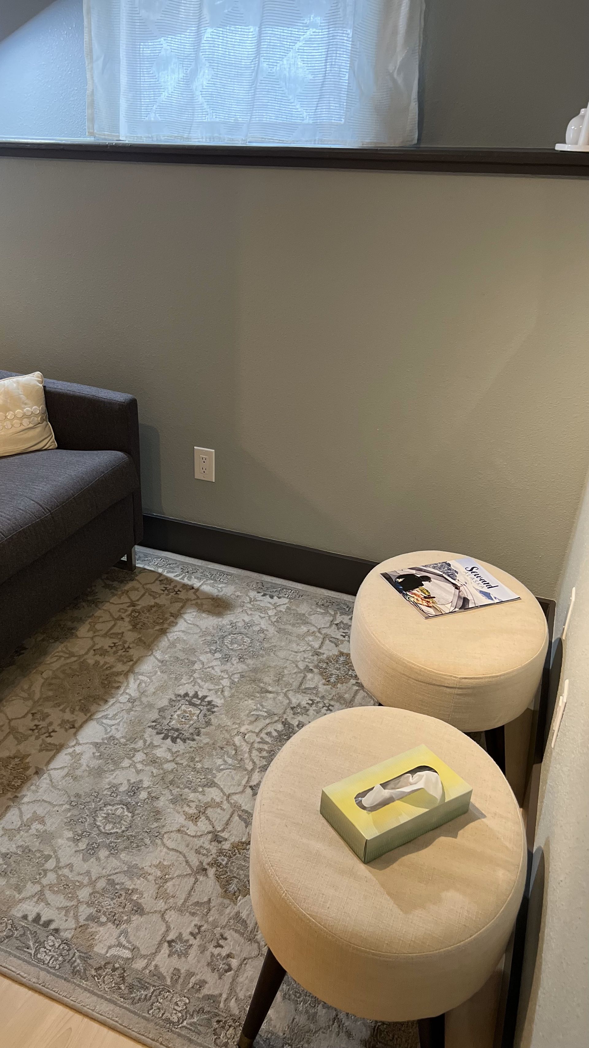 A living room with two ottomans and a couch.