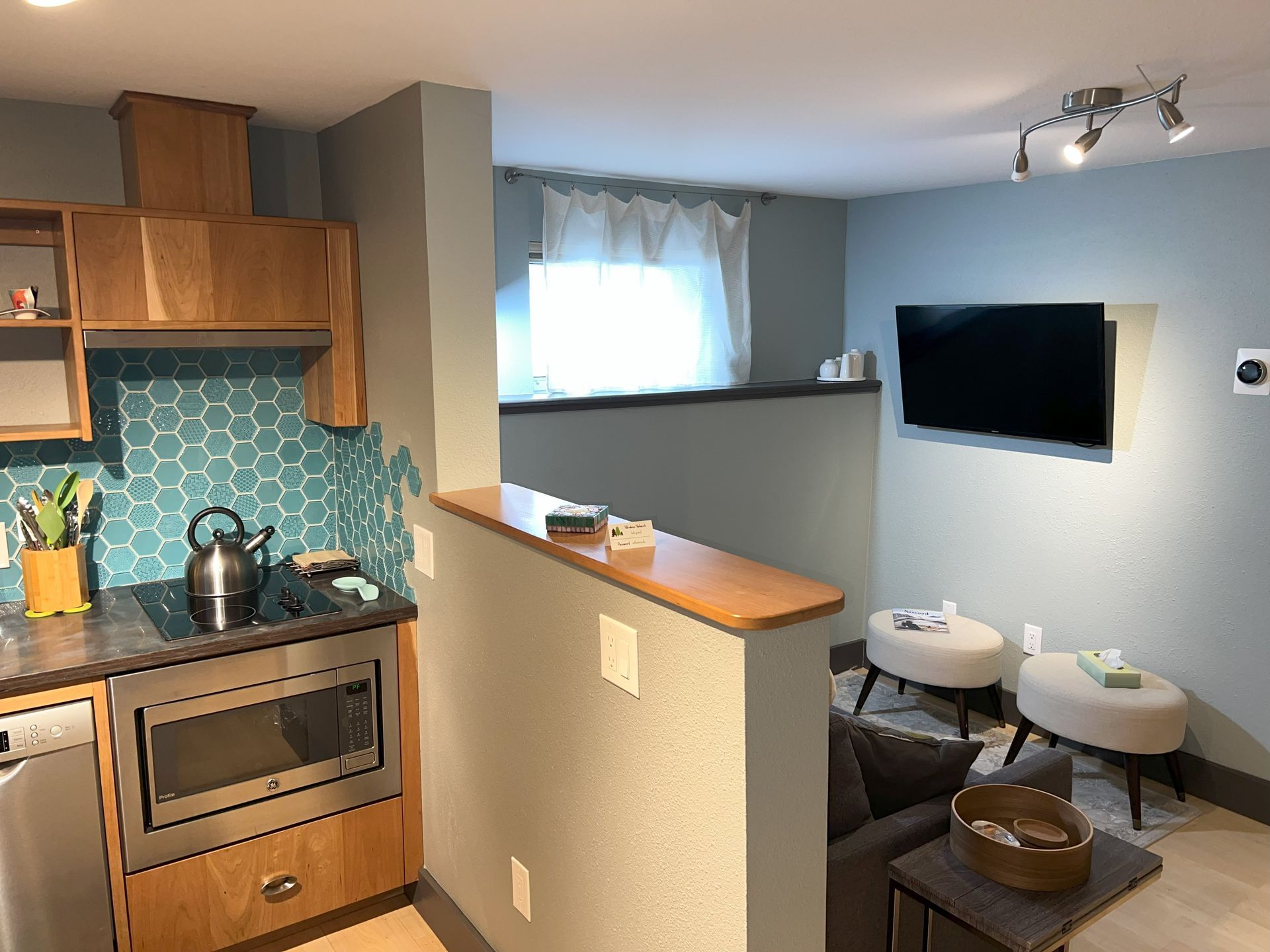 A kitchen with a microwave oven and a flat screen tv
