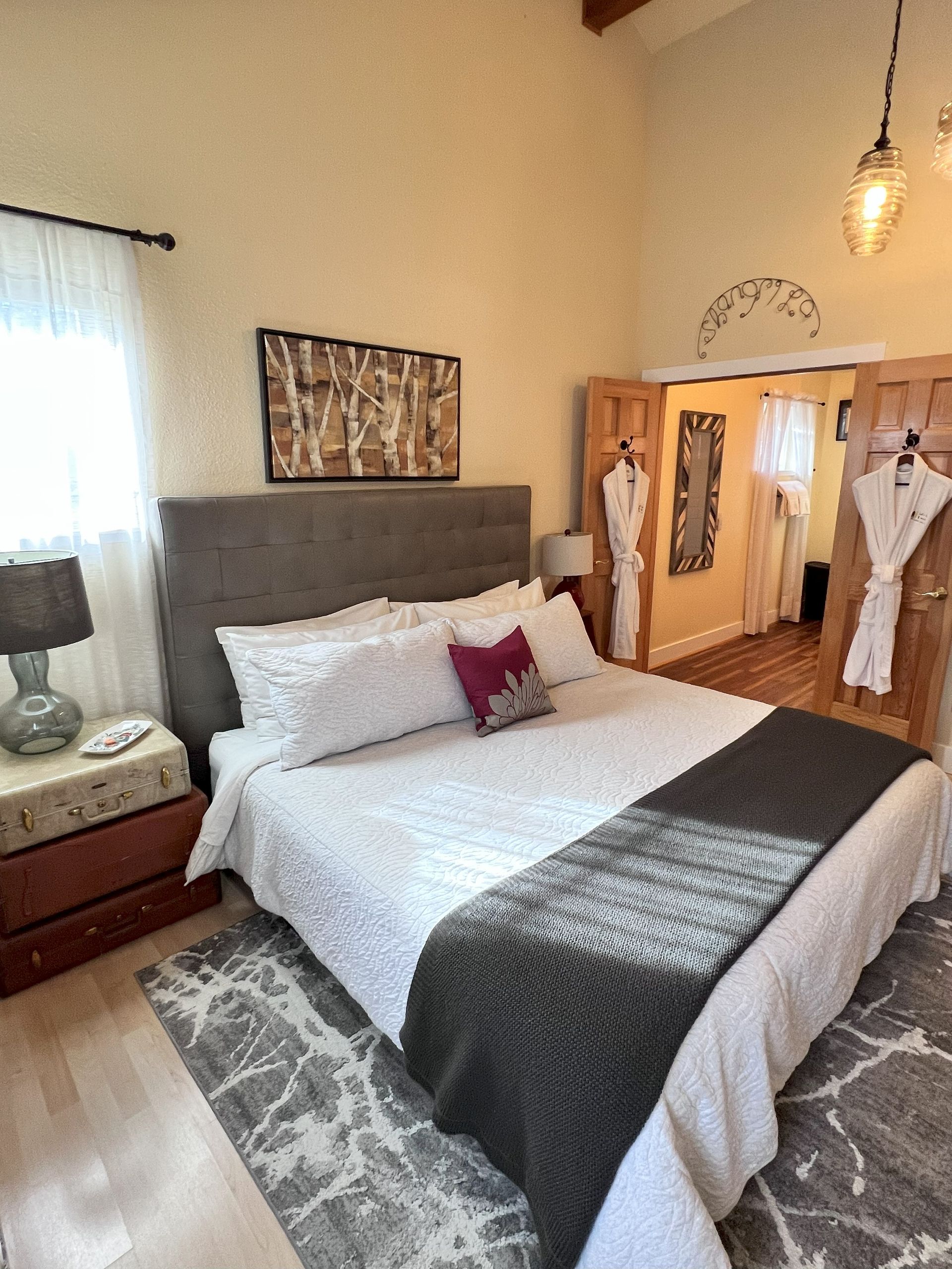 A bedroom with a large bed and a nightstand