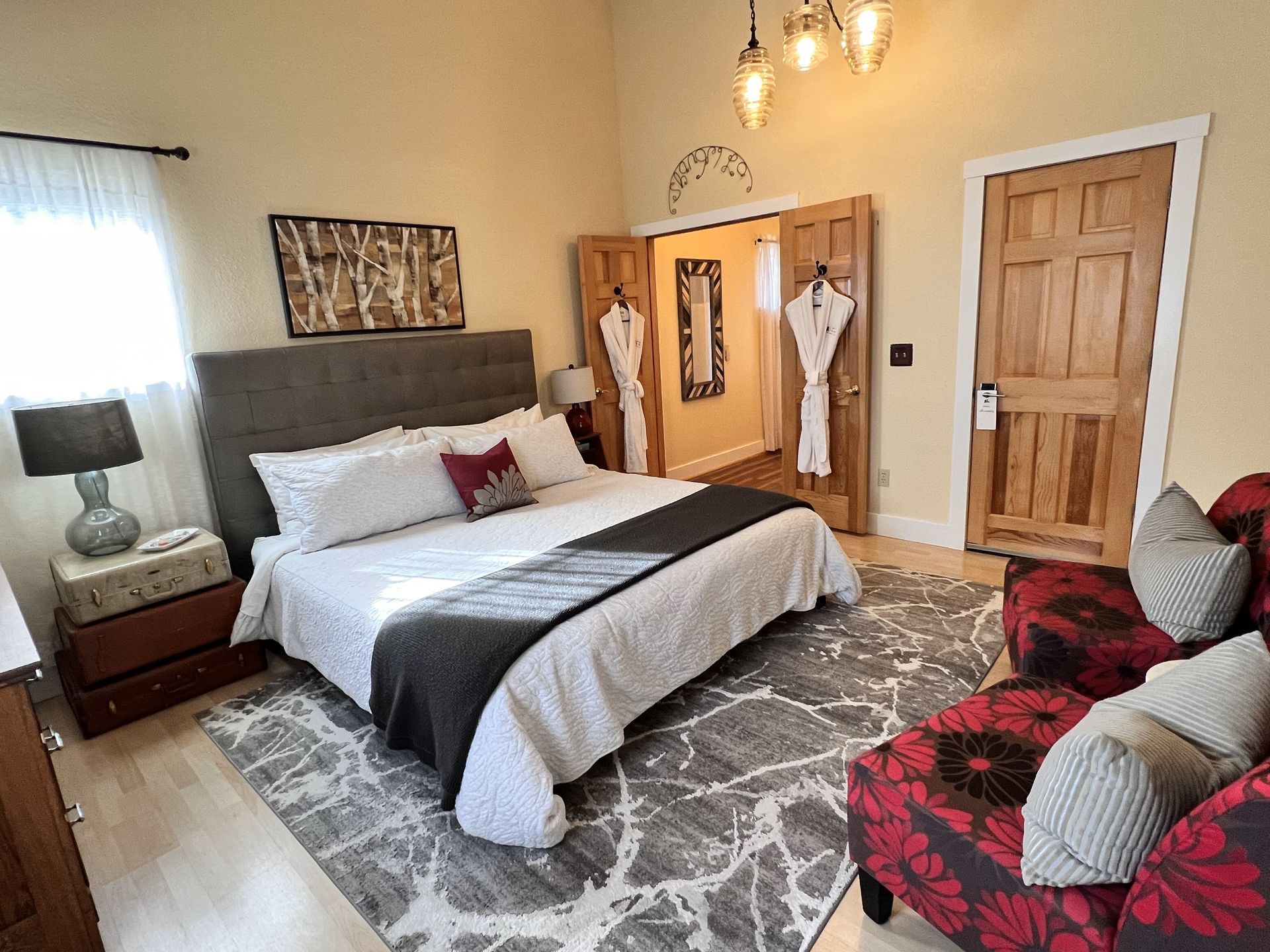 A bedroom with a king size bed , a couch , and a rug.
