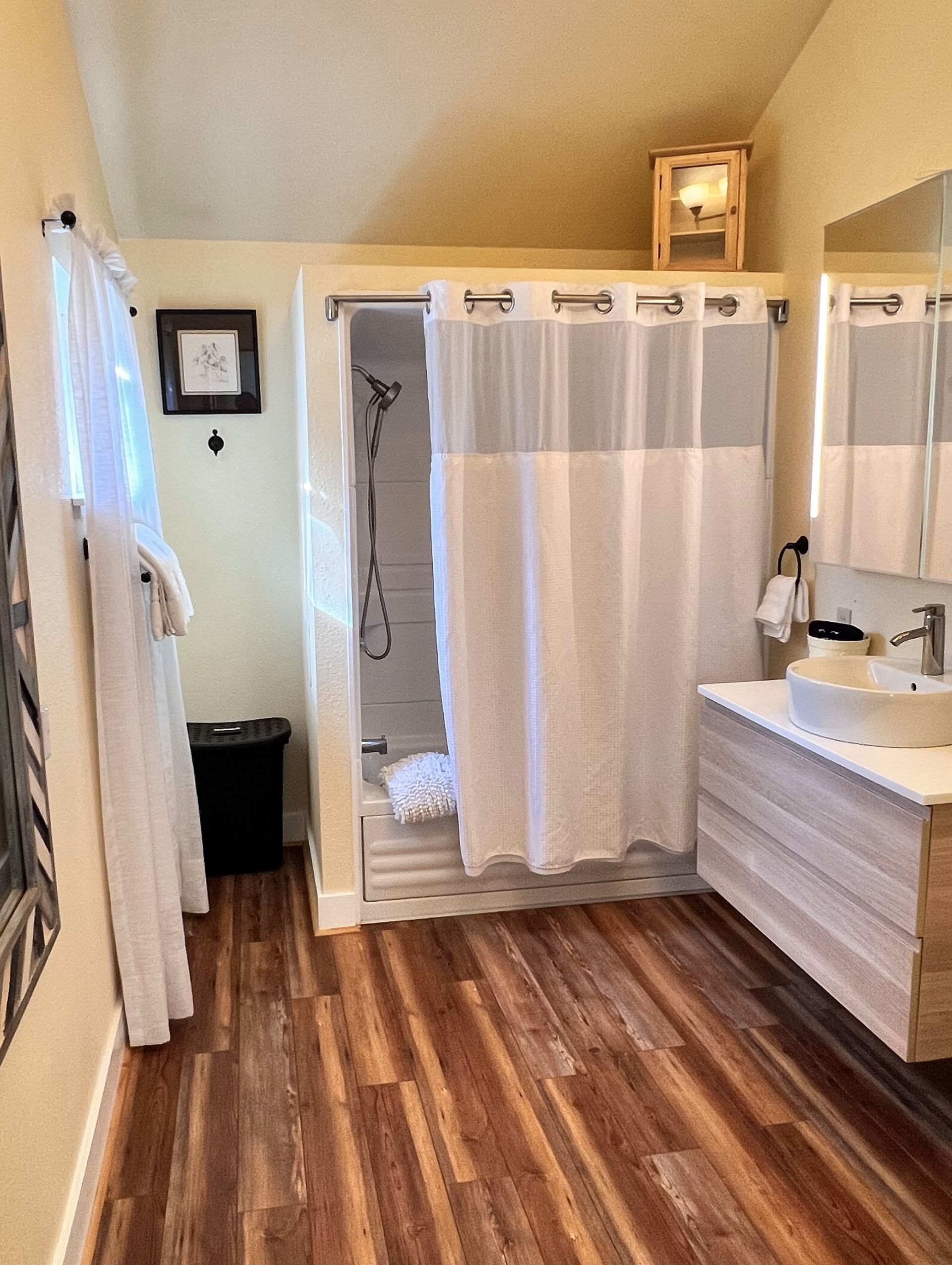 A bathroom with a sink , shower , and shower curtain.