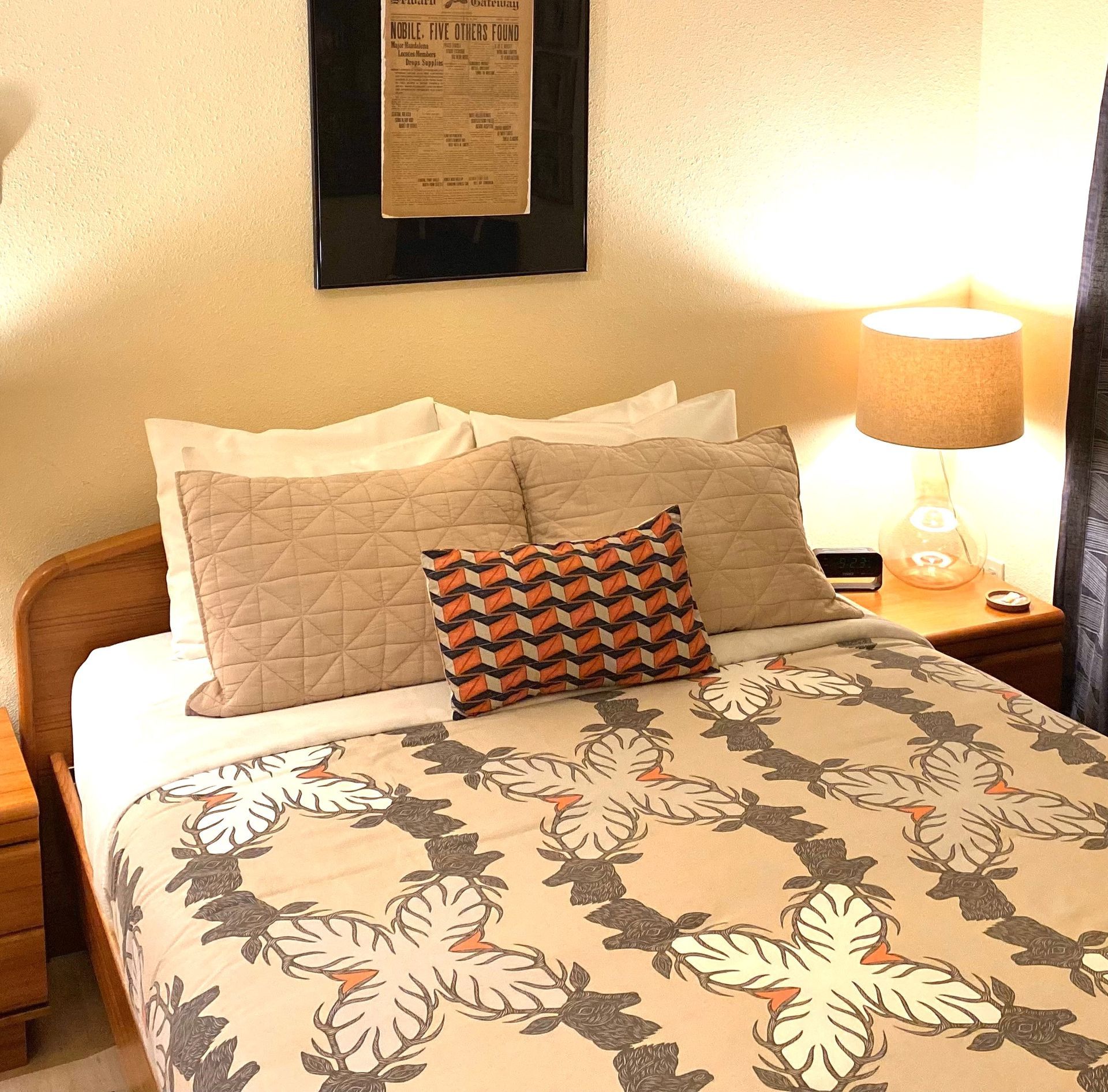 A bed with a butterfly blanket and pillows in a bedroom