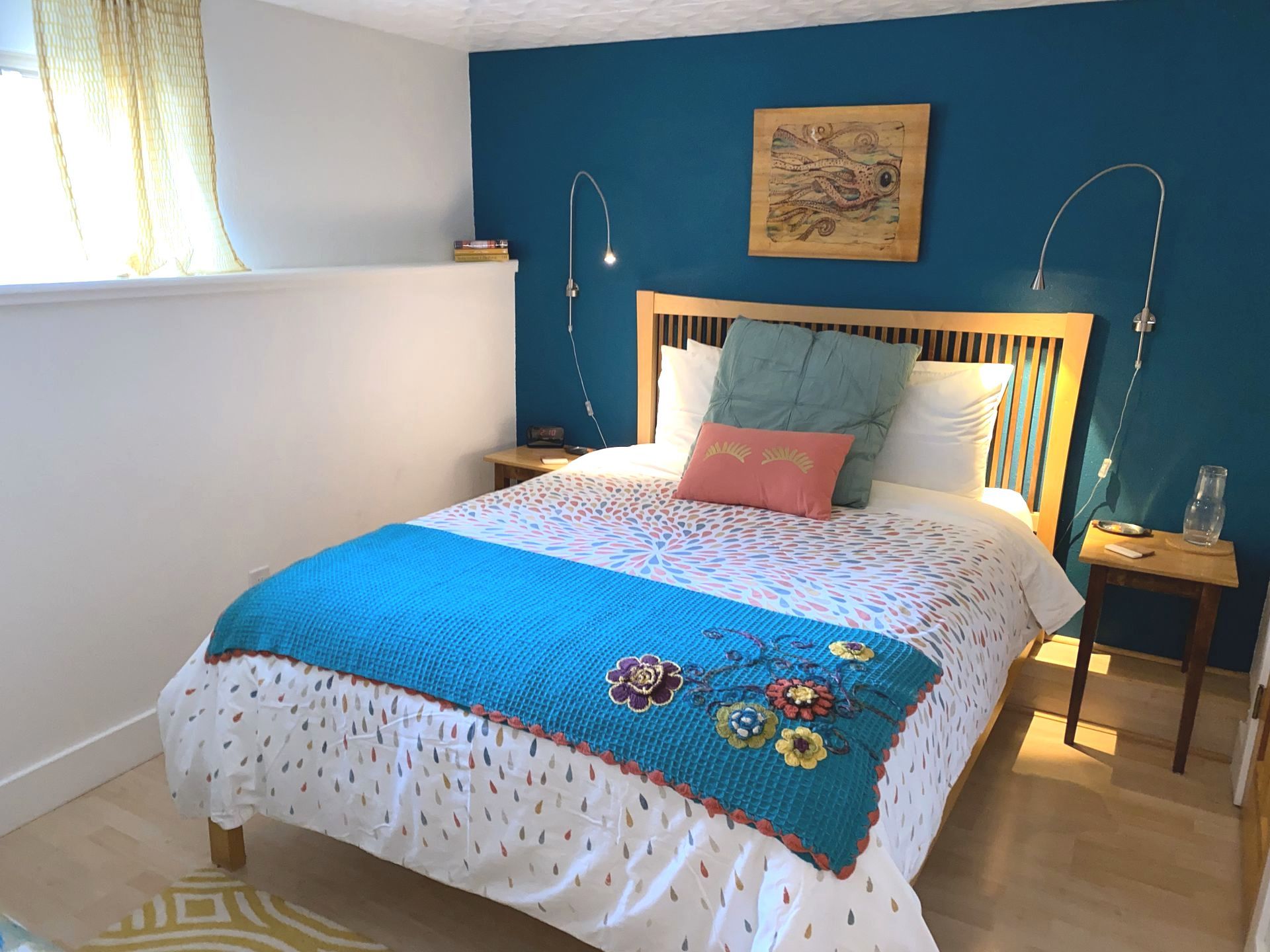 A bedroom with a bed and a blue wall.
