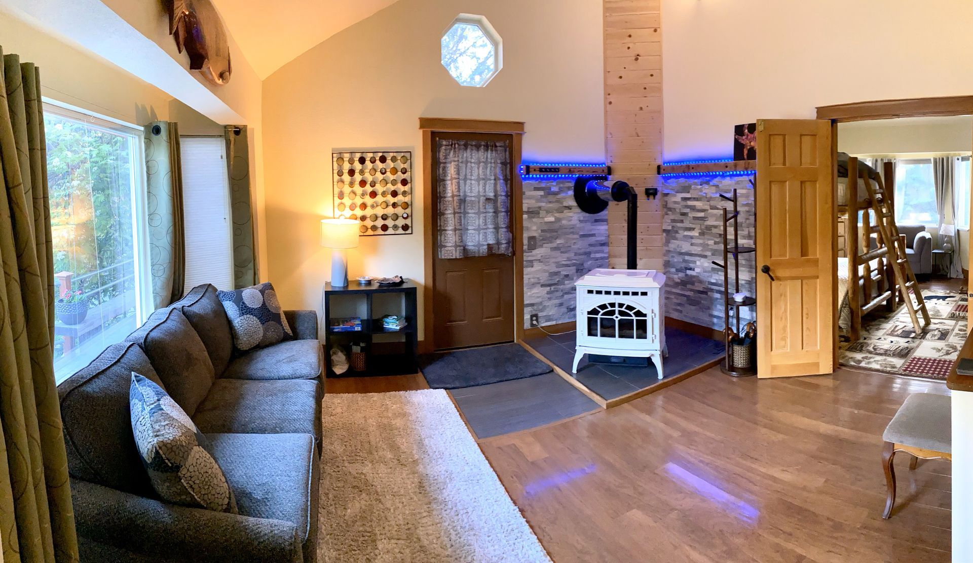 A living room with a couch and a wood stove.