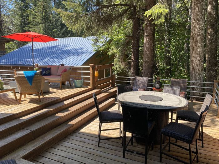 A wooden deck with a table and chairs and an umbrella.