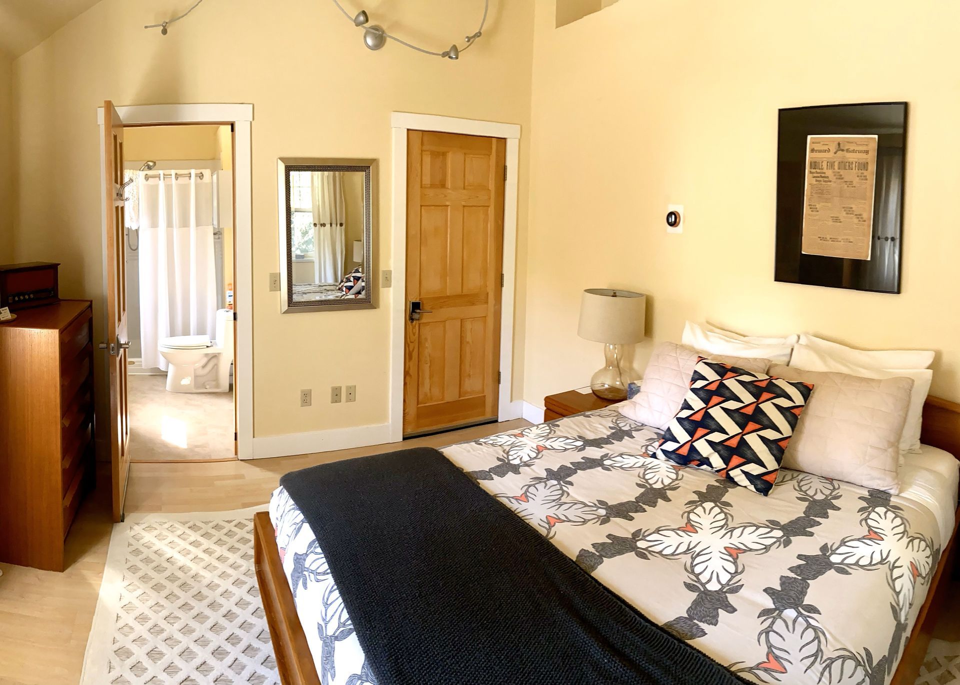 A bedroom with a large bed and a dresser