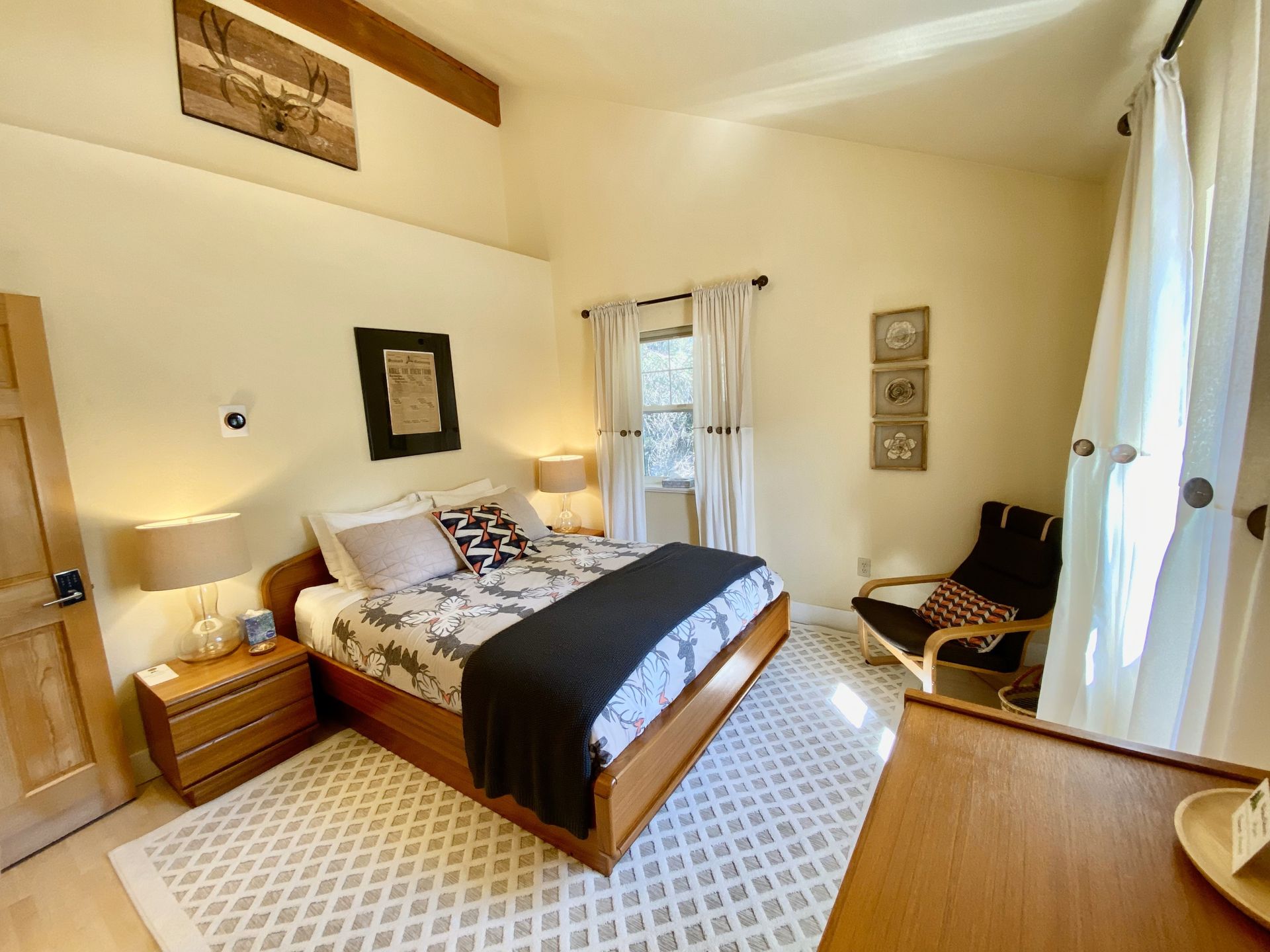 A bedroom with a king size bed , nightstand , chair and dresser.