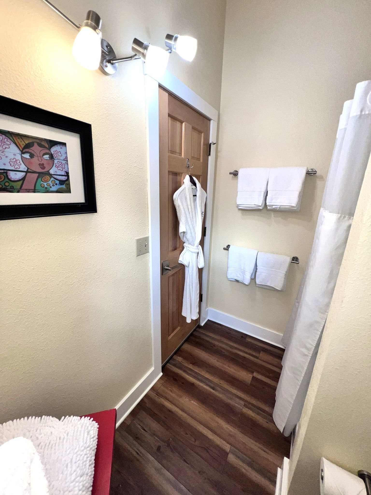 A bathroom with a bathrobe hanging on the door