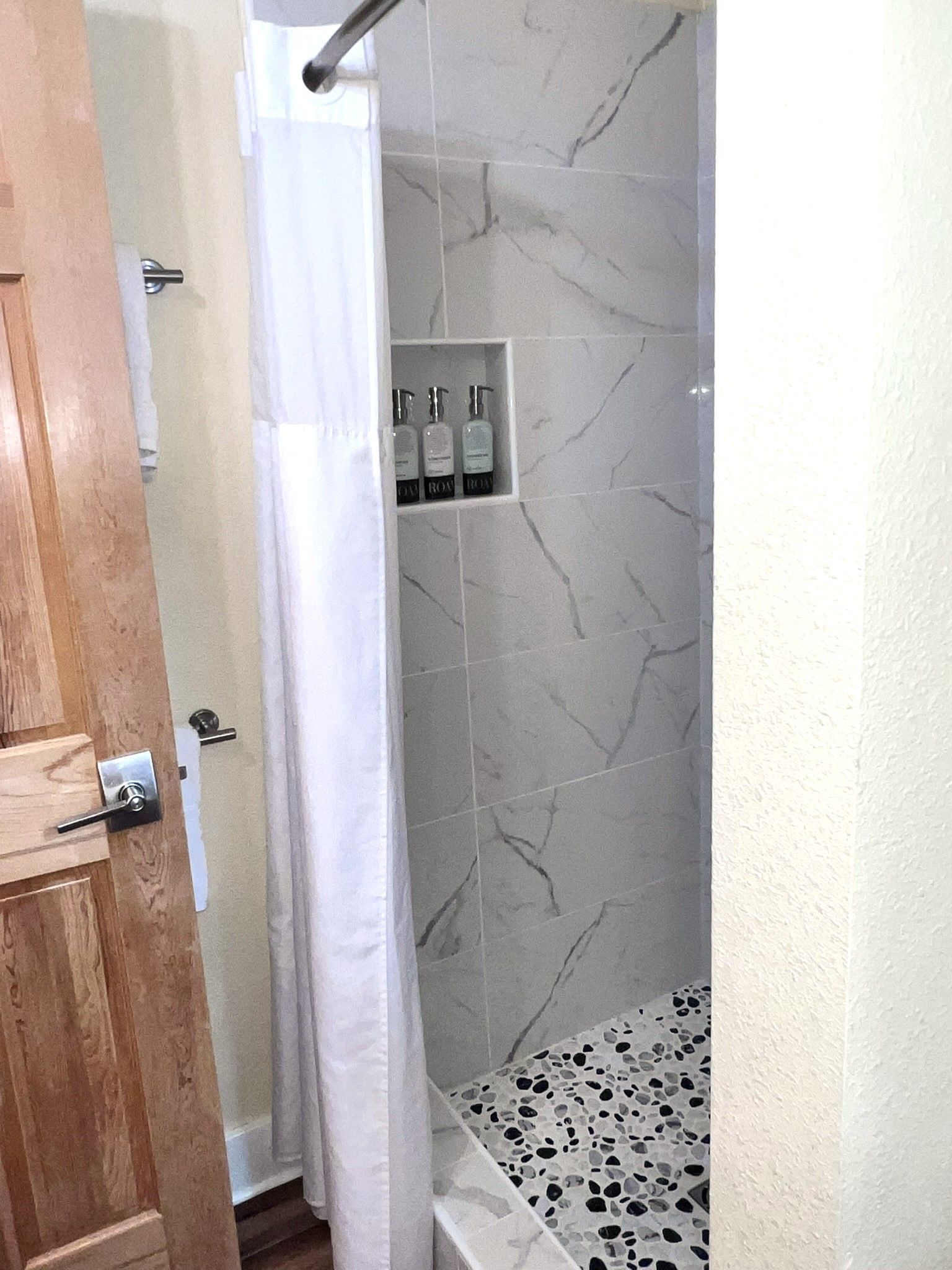 A bathroom with a shower curtain and a bathtub.