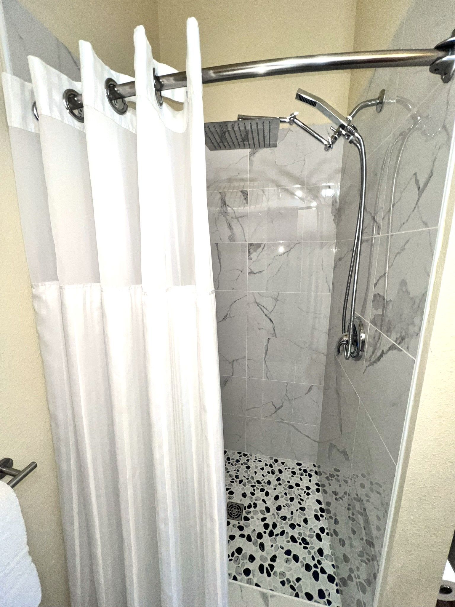 A shower with a shower curtain and a shower head.